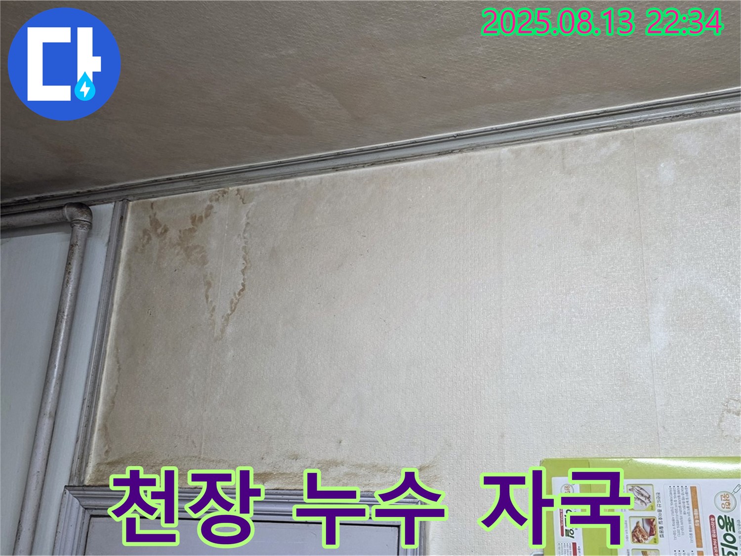 천장에 남은 누수 자국 - 물이 흘러내려 생긴 얼룩과 변색된 천장 벽지를 보여줍니다.