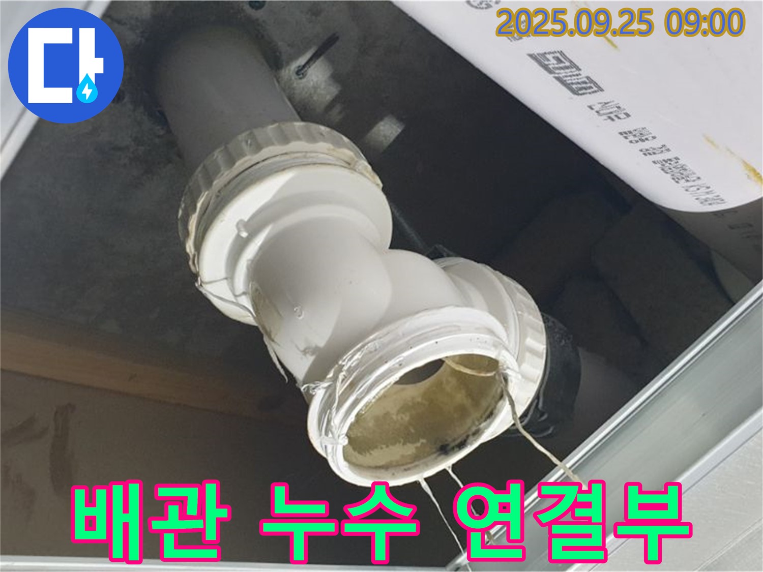 배관 연결 부위에서 누수가 발생하여 주변으로 물이 떨어지고 있는 상황을 보여주는 이미지입니다.