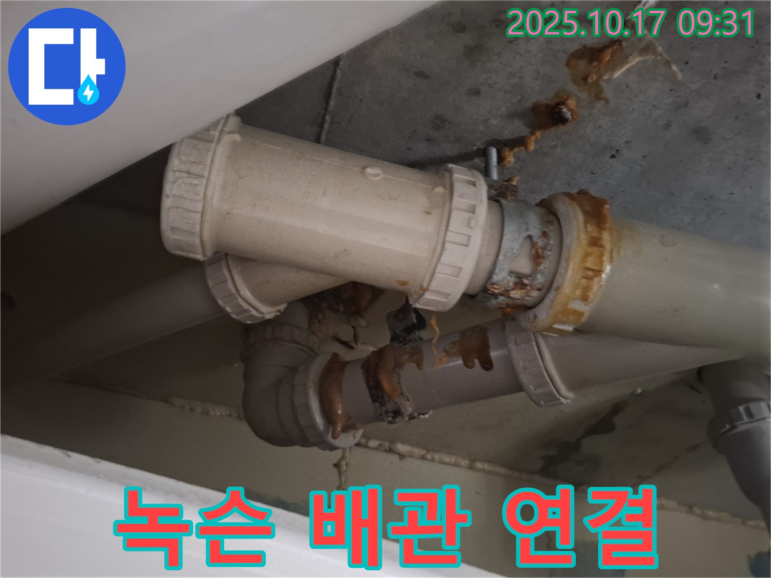 녹슨 배관 연결 - 배관 연결 부위가 녹슬고 부식되어 누수가 발생하고 있습니다. 즉시 보수가 필요합니다.