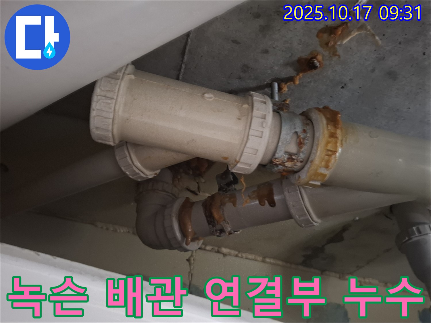 녹슨 배관 연결부 누수 - 배관 연결 부위가 심하게 녹슬어 누수가 발생하고 있습니다 - 즉시 보수가 필요합니다.