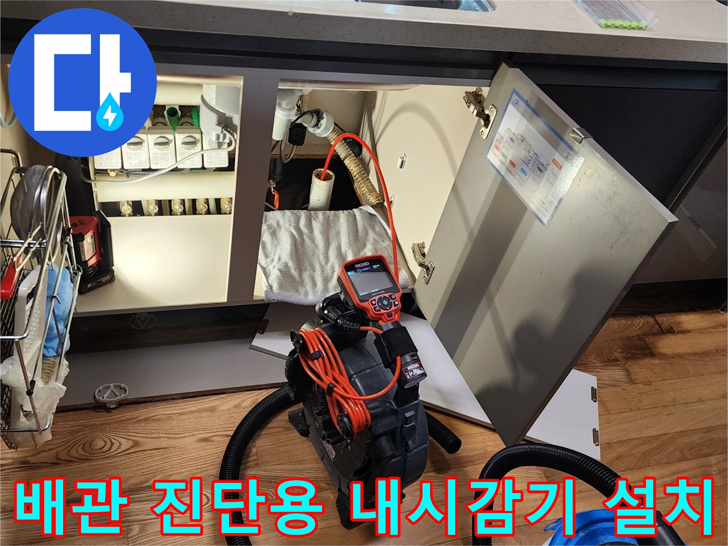 싱크대 하부 배관 점검을 위해 설치된 전문 내시경 장비와 흡입기