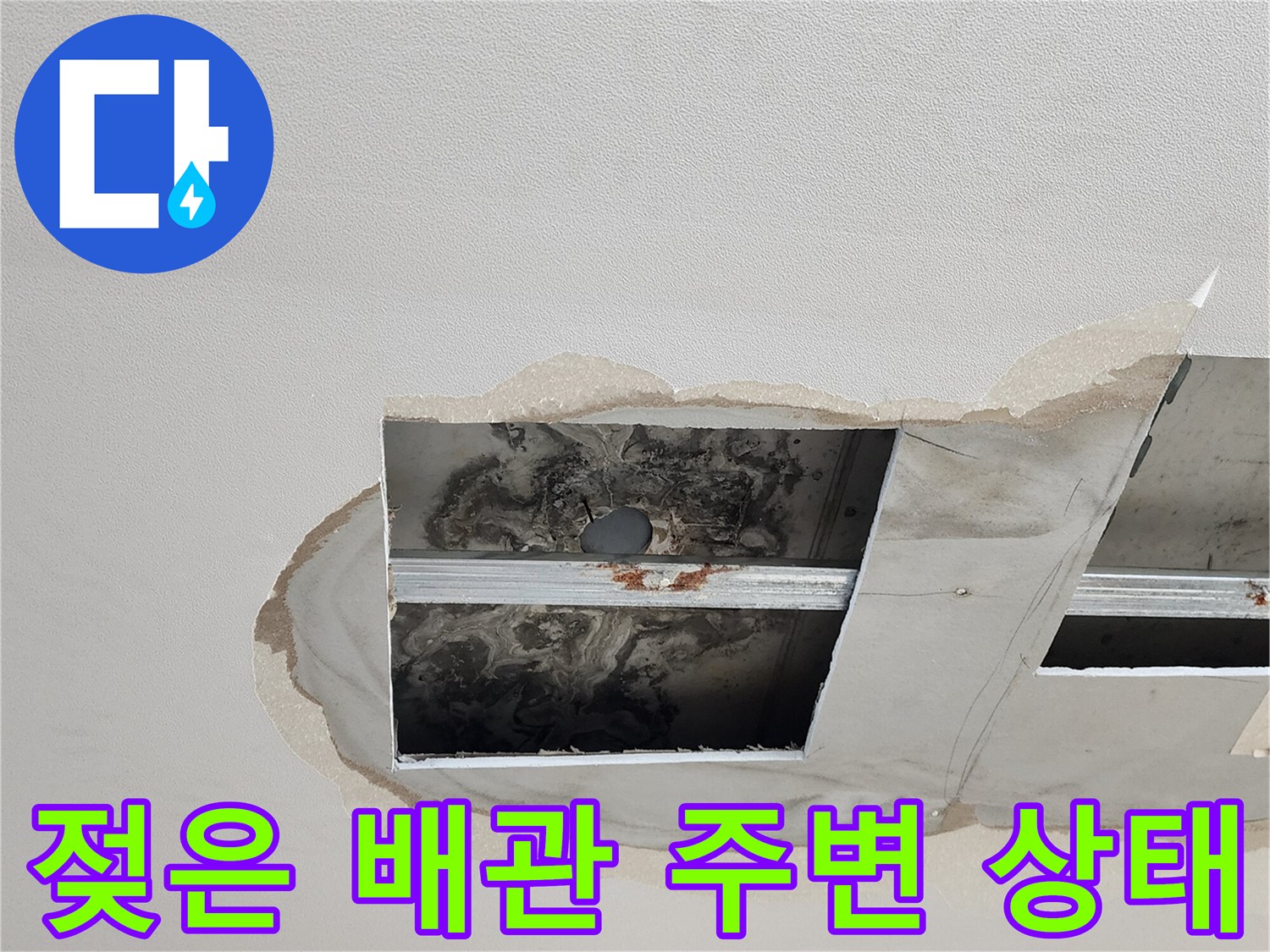 천장 점검구 내부의 젖은 배관과 오염된 마감재