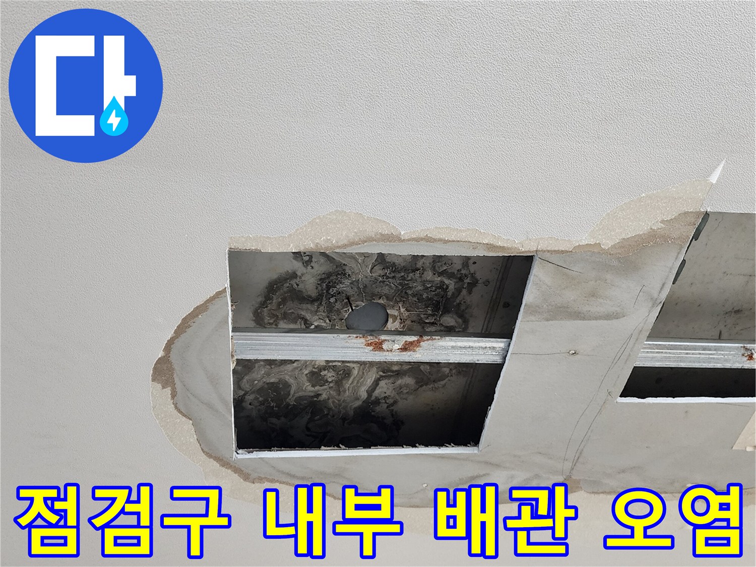 천장 점검구 안쪽의 습기 찬 배관과 얼룩진 마감재