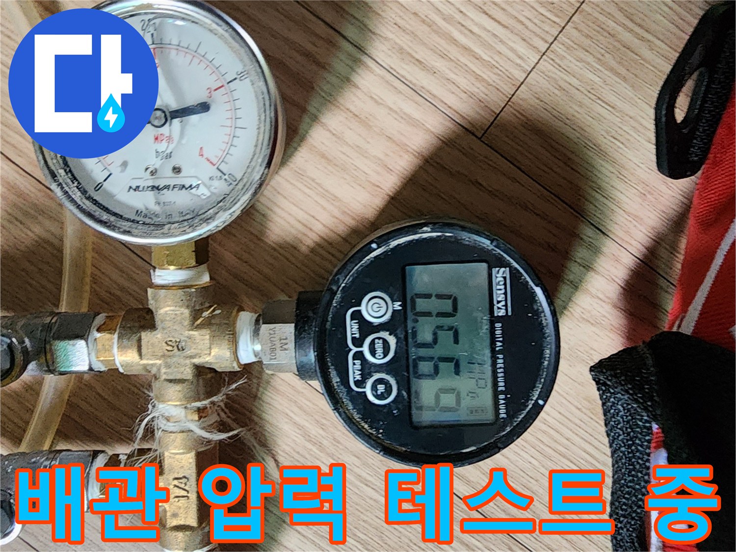 금속 배관 연결 부위에 디지털 압력계를 설치하여 누수 여부를 진단하는 현장 사진입니다.