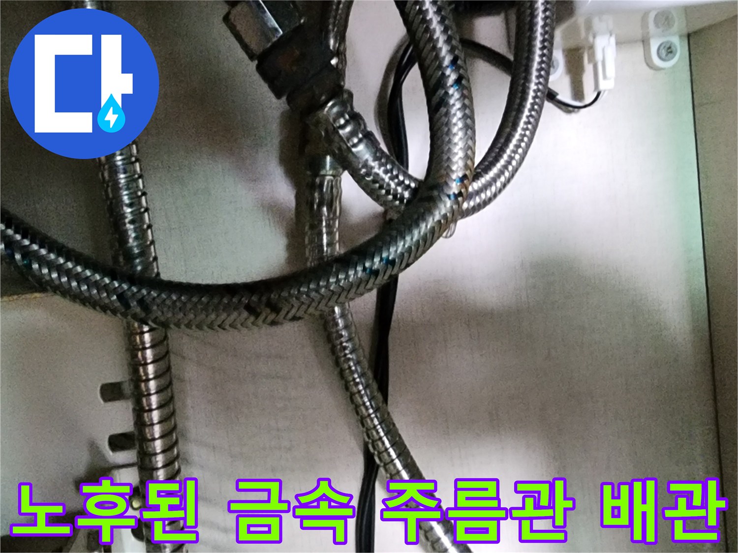 싱크대 하부의 굴곡진 금속 배관과 연결 소켓 부위