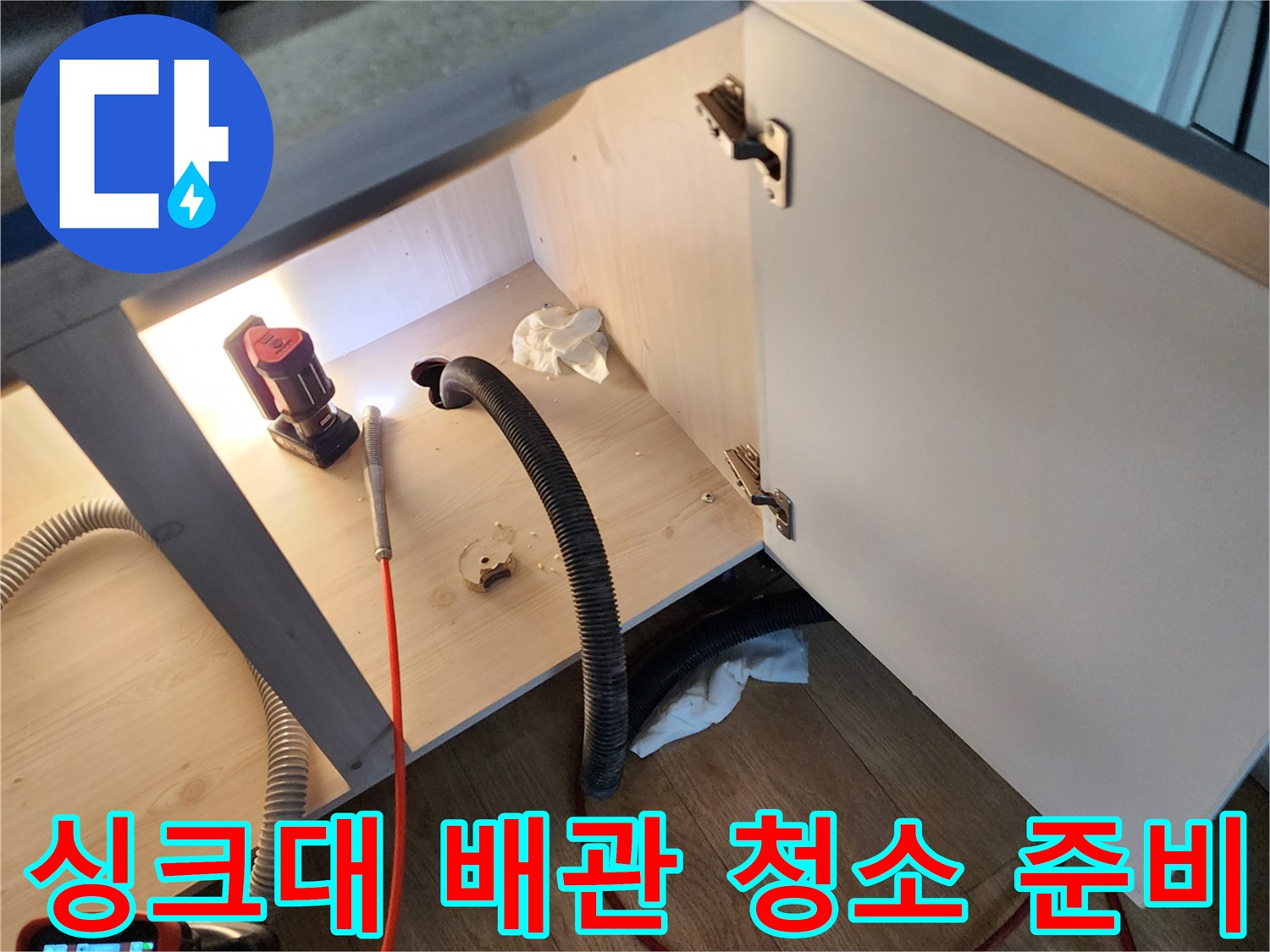 싱크대 밑 배관 점검을 위해 연결된 검은색 흡입 호스
