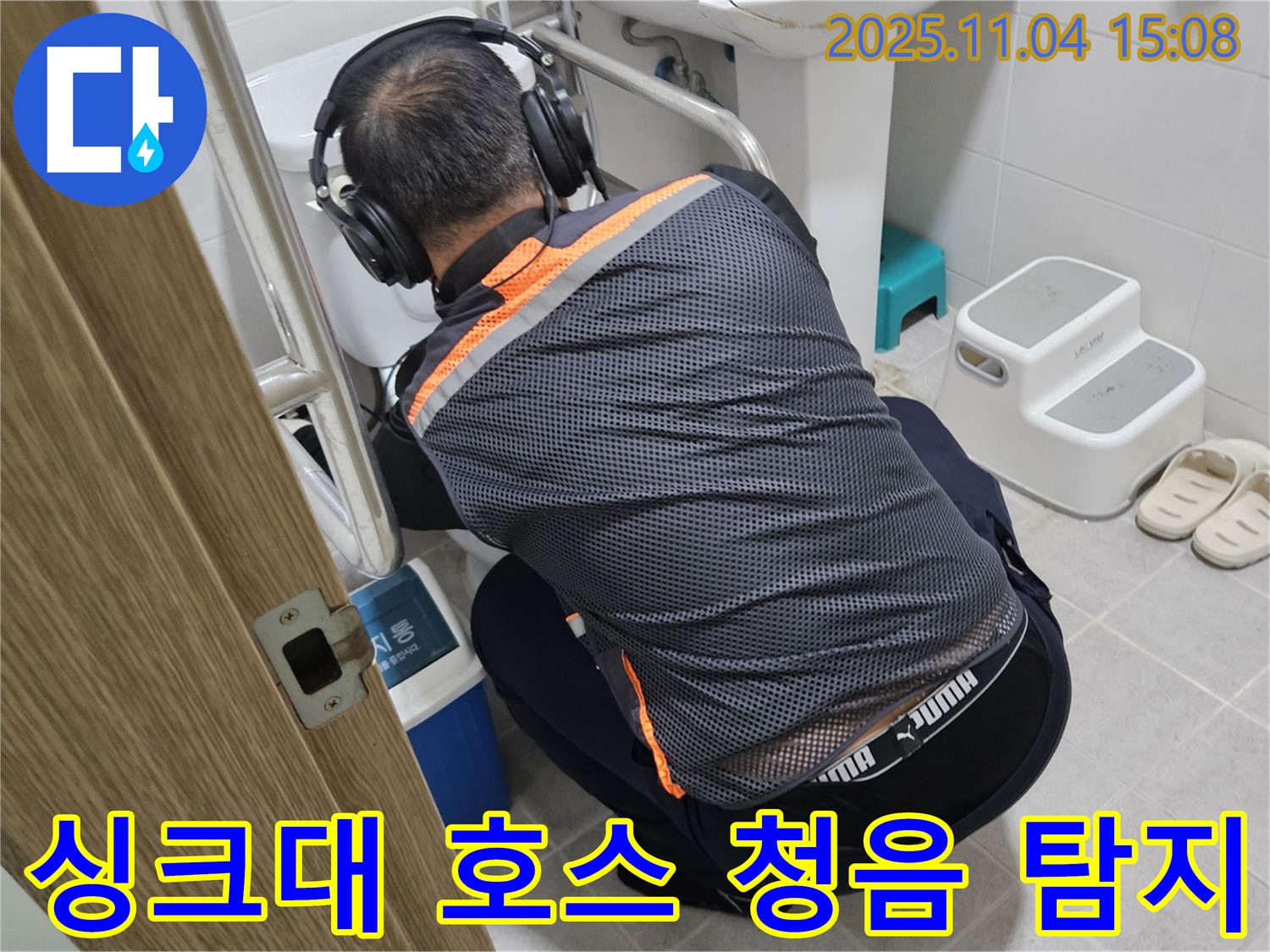 누수 전문가가 싱크대 호스 연결 부위에 청음 탐지 장비를 대고 누수 여부를 확인하고 있습니다 - 꼼꼼한 탐지로 숨은 누수까지 찾아냅니다.