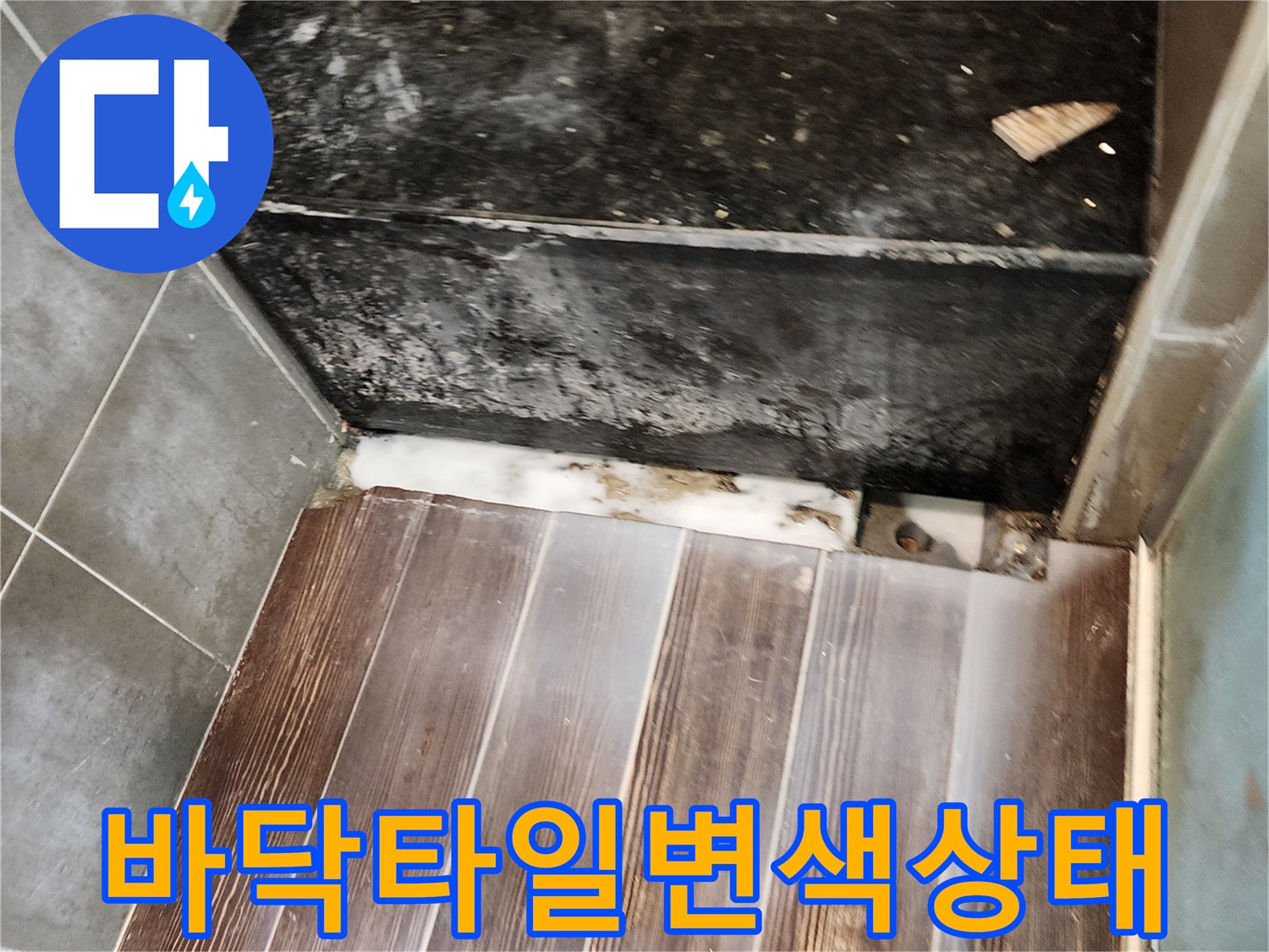 나무 패턴 타일과 검은 마감재 사이의 습기 및 오염 부위