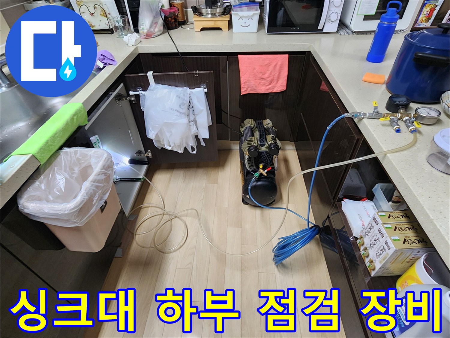 누수 지점 확인을 위해 싱크대 아래에 설치된 공압 테스트 장비 세트