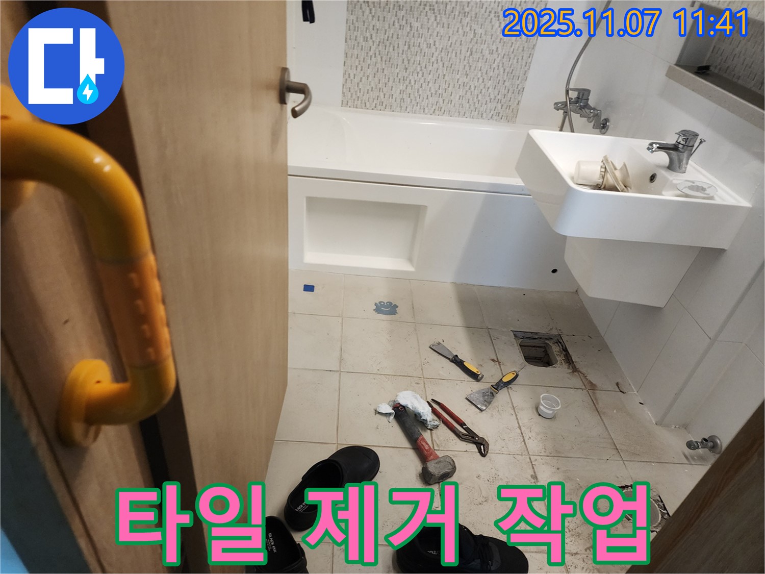 사우동 욕실 누수 - 망치와 정을 사용하여 문제 타일을 조심스럽게 제거하는 모습입니다.