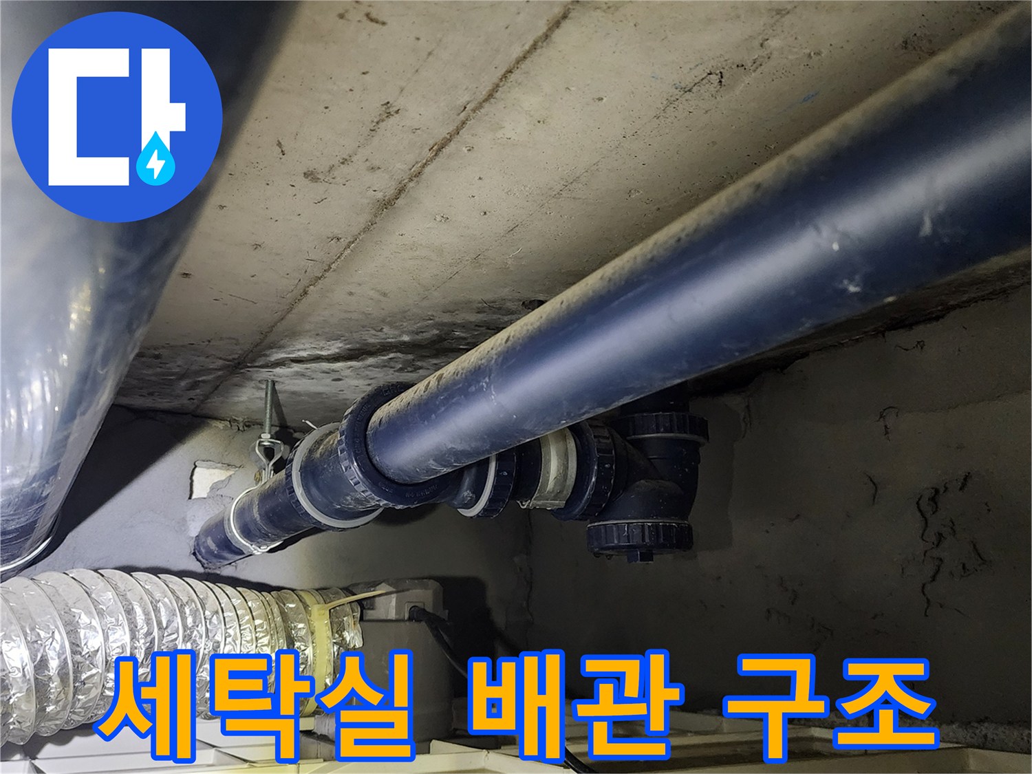 세탁실 천장 내부의 검은색 급수 배관과 밸브 연결부 근접 촬영