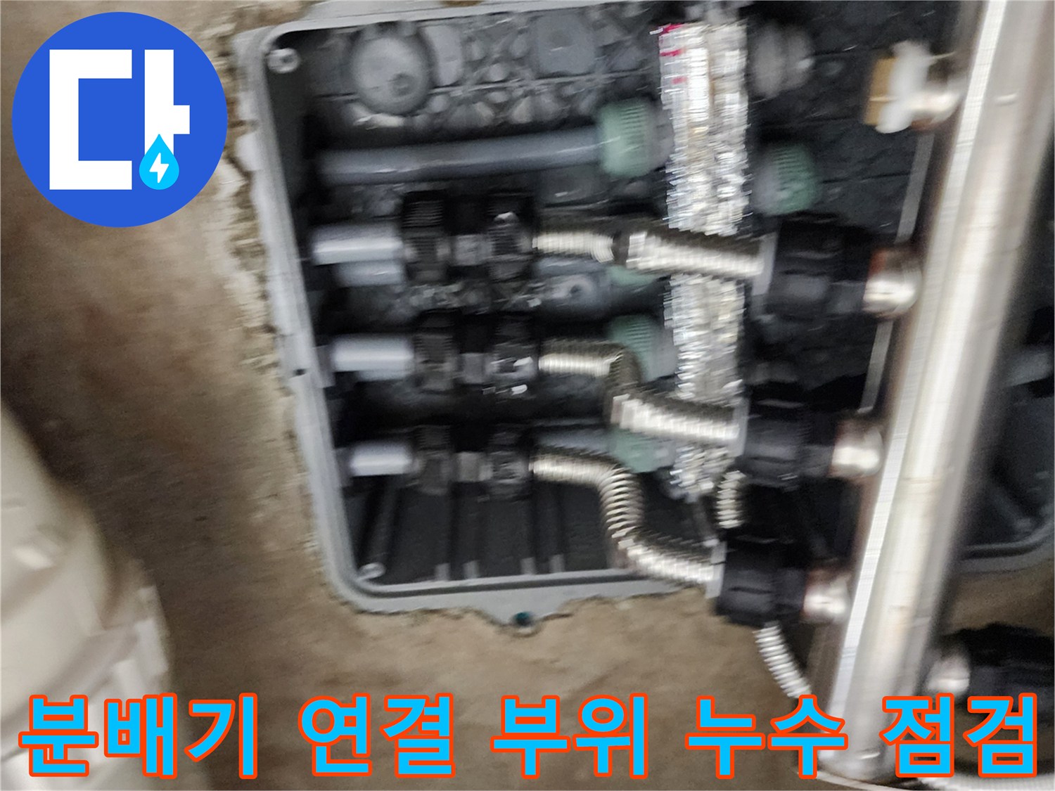 매립된 공간 속 스테인리스 분배기와 은색 연결 배관들