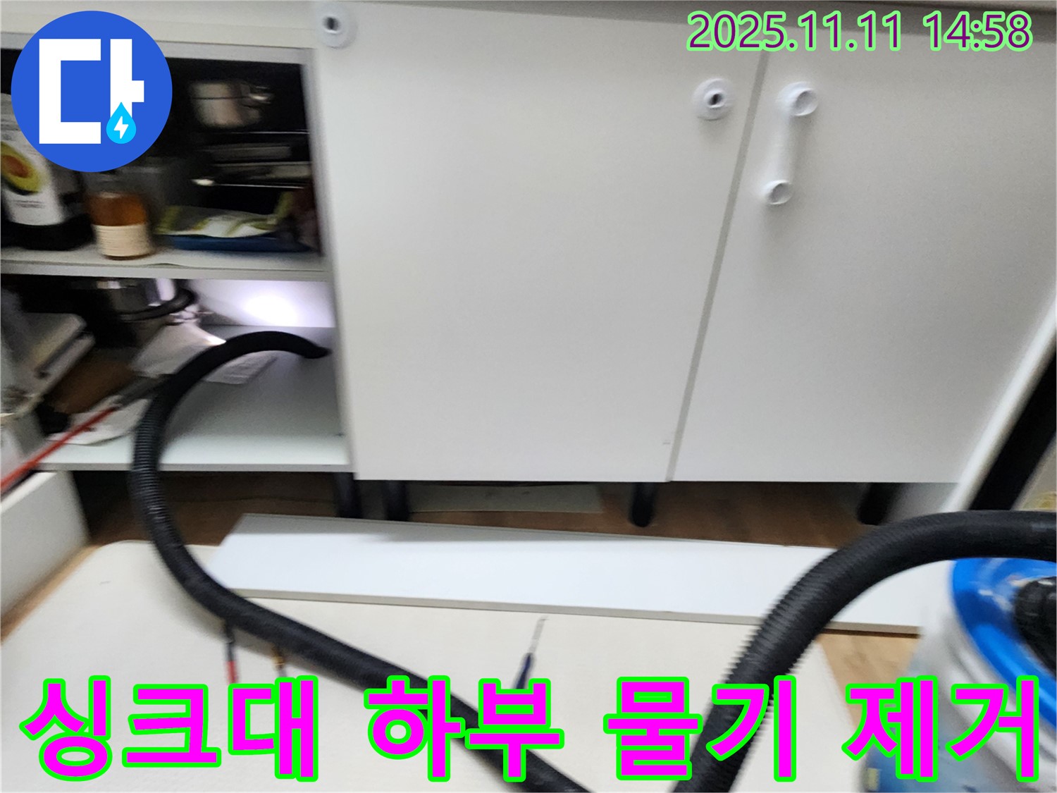 싱크대 하부 물기 제거 - 누수 후 남은 물기를 흡입기로 꼼꼼하게 제거하고 있습니다.