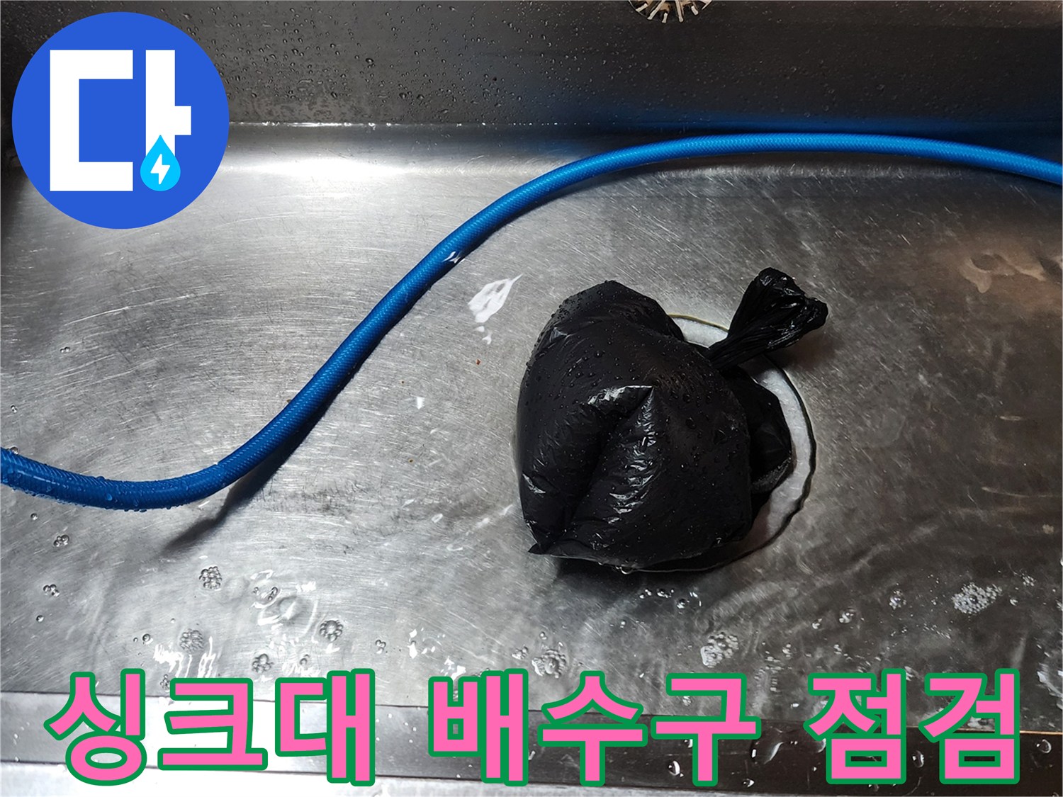 스테인리스 싱크대 내부-배수구 주변 검은 비닐 뭉치와 파란 호스