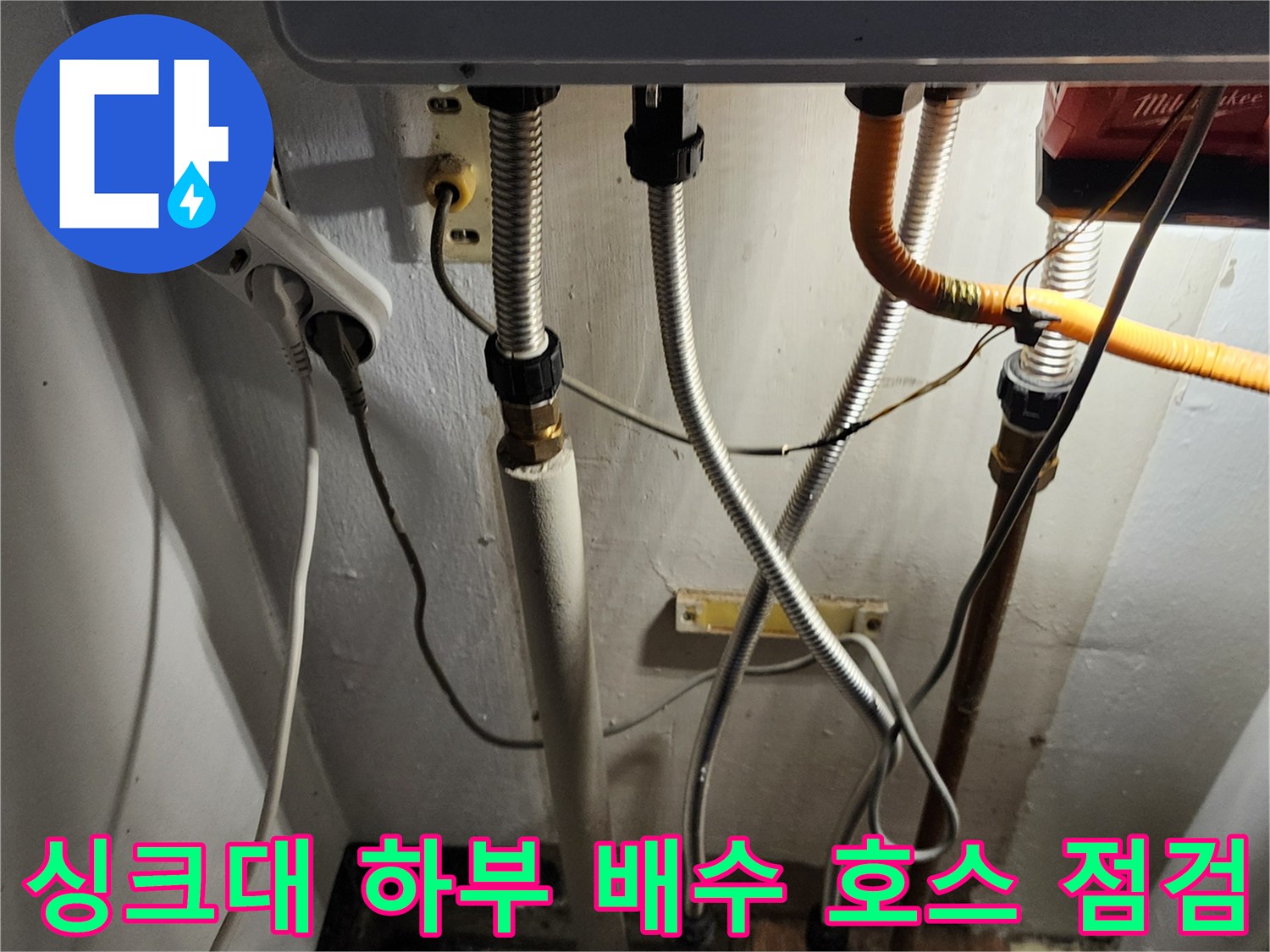 싱크대 아래쪽의 은색 주름관과 노란색 튜브 연결 부위