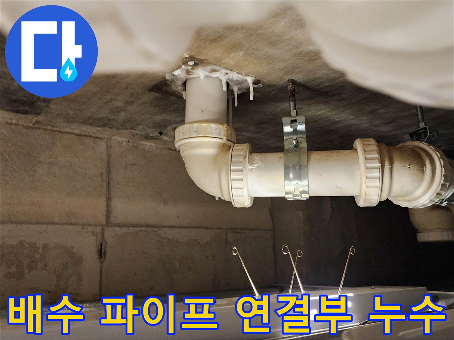 누수가 진행된 배수관-파이프 주변의 물샘과 석회 자국을 보여줍니다.