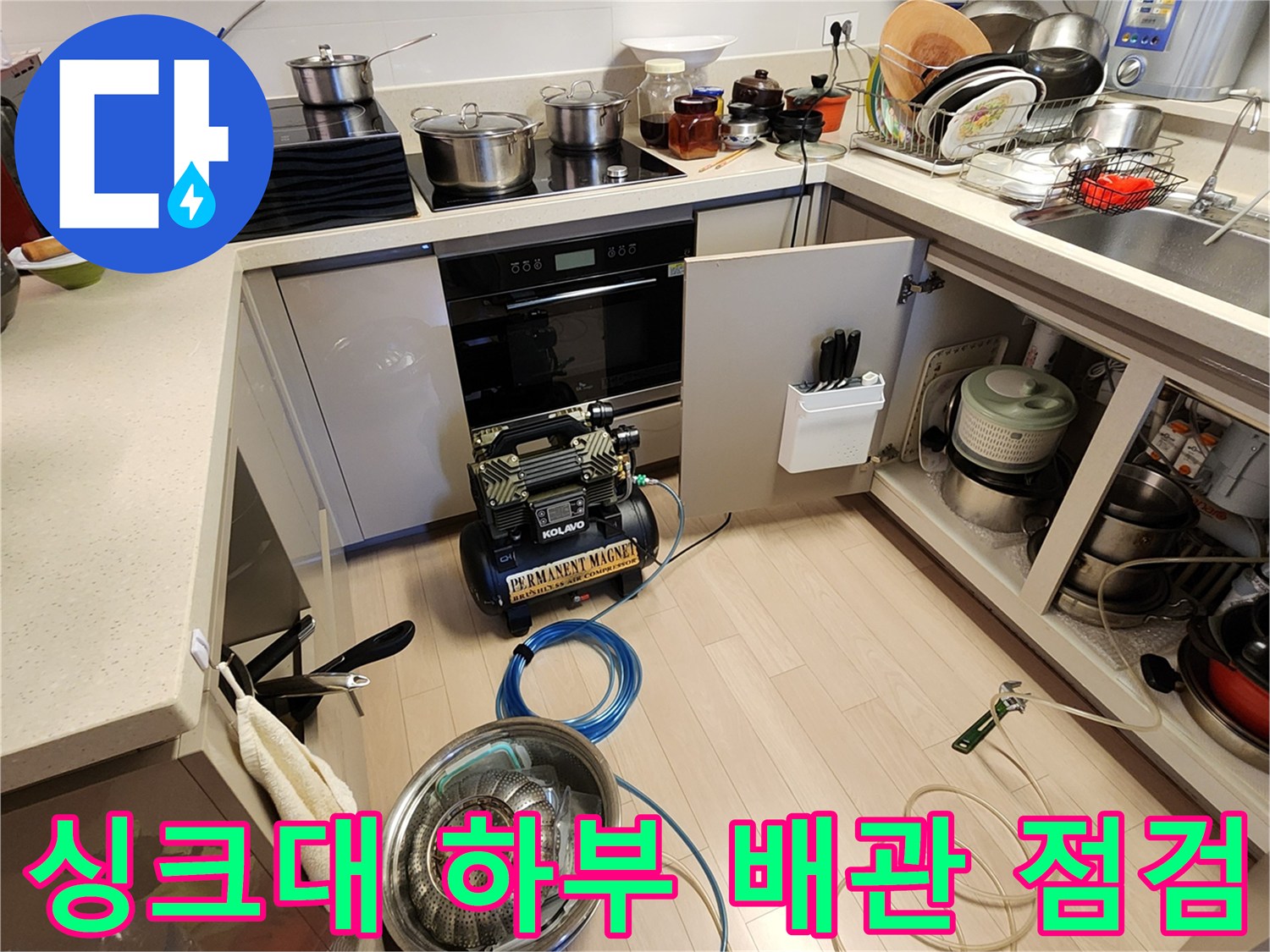 주방 싱크대 하단 공간에 배치된 누수 탐지용 장비 세트