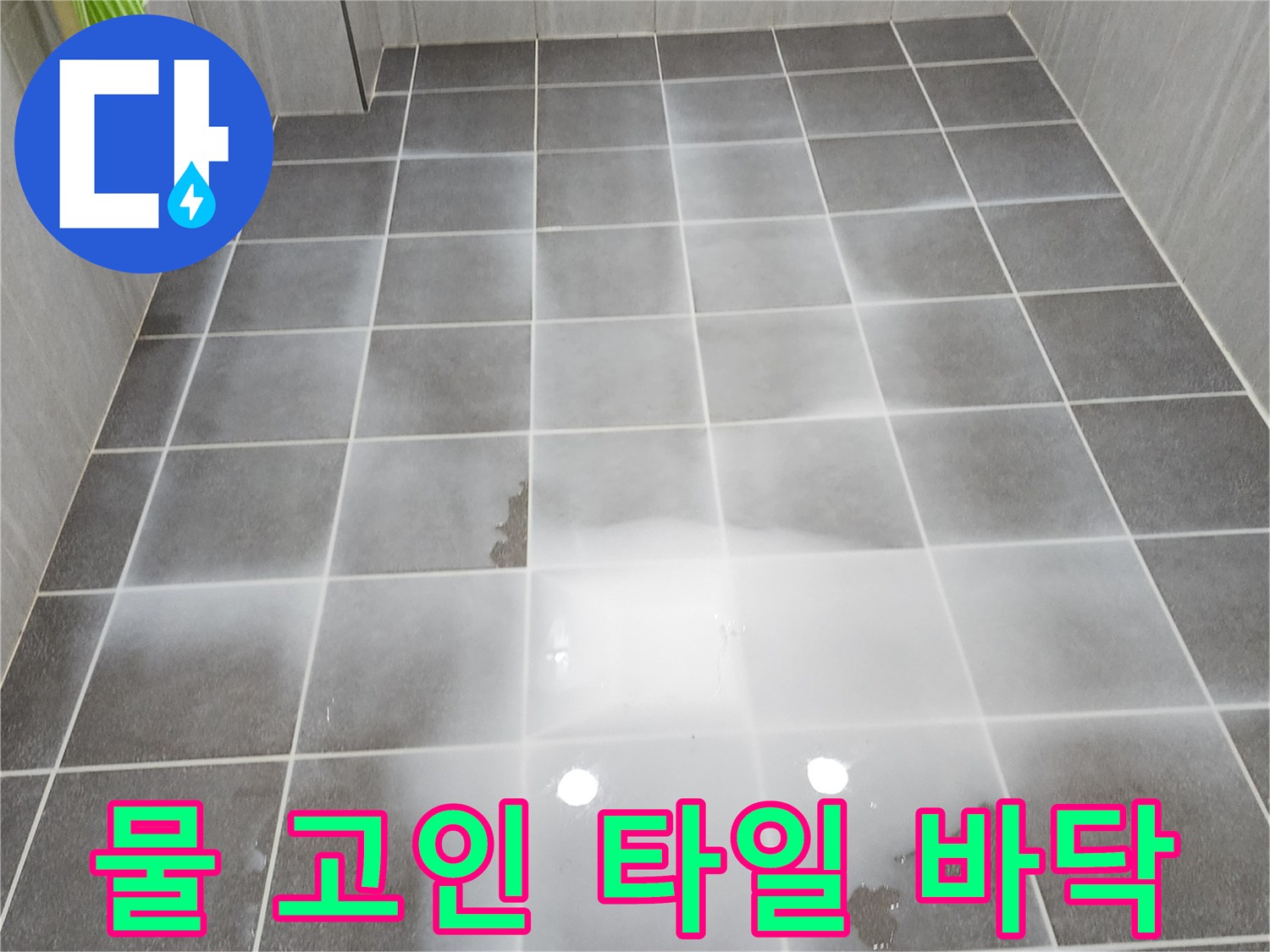 회색 욕실 타일 위에 물이 찰랑거리게 고여 있는 사진