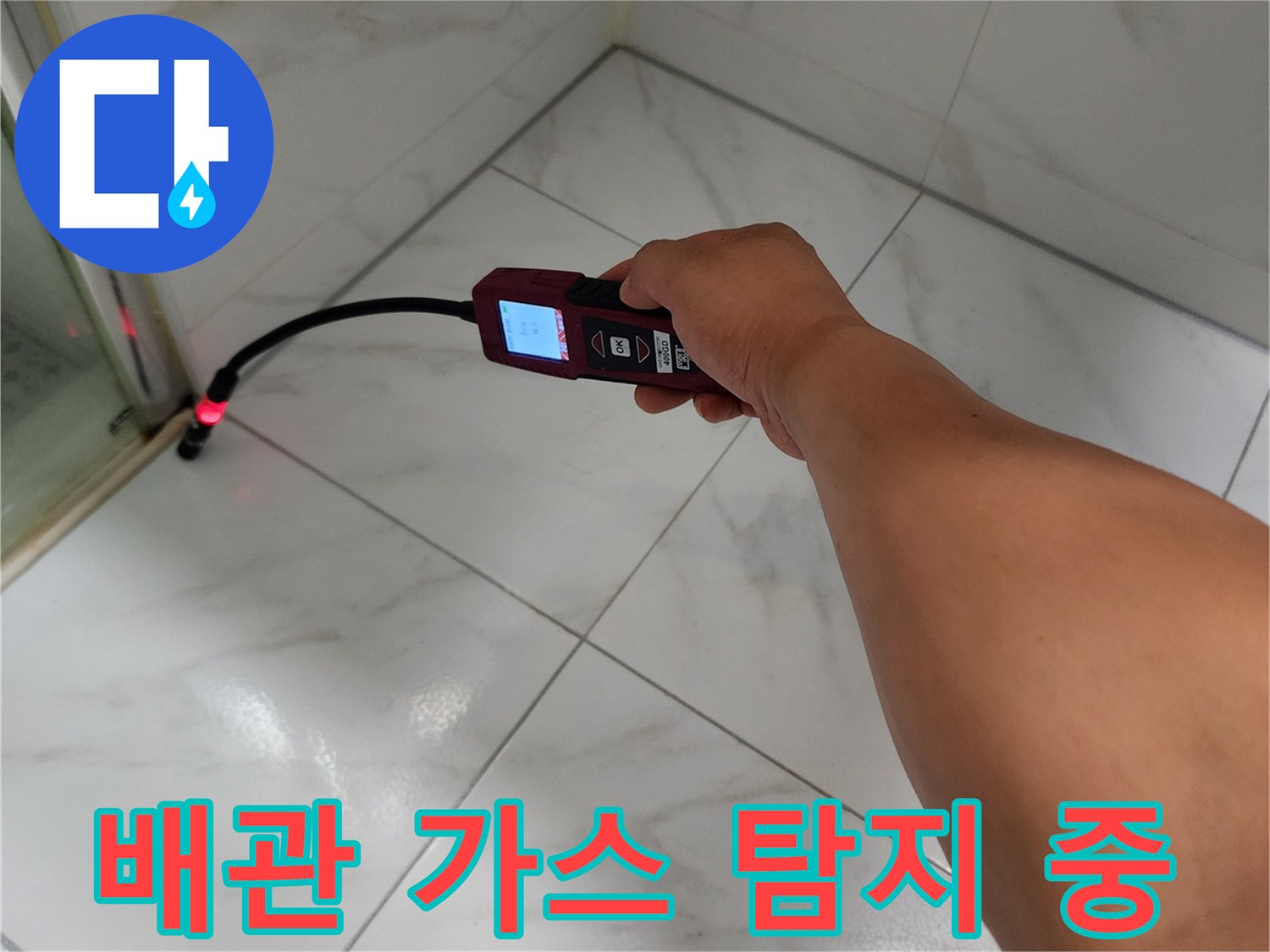 하얀색 타일 바닥 위에서 작동 중인 휴대용 가스 탐지기