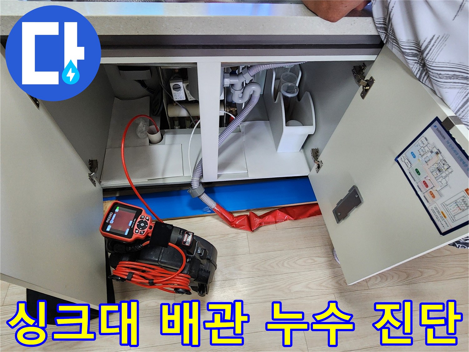 싱크대 하부 배관에 빨간색 호스가 연결된 공압 테스트 장면