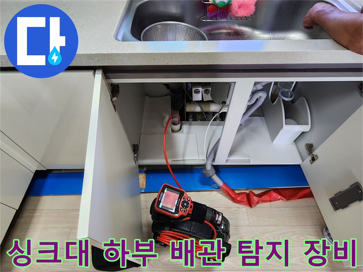 주방 싱크대 하부장에 설치된 전문 배관 탐지기와 연결된 호스 모습