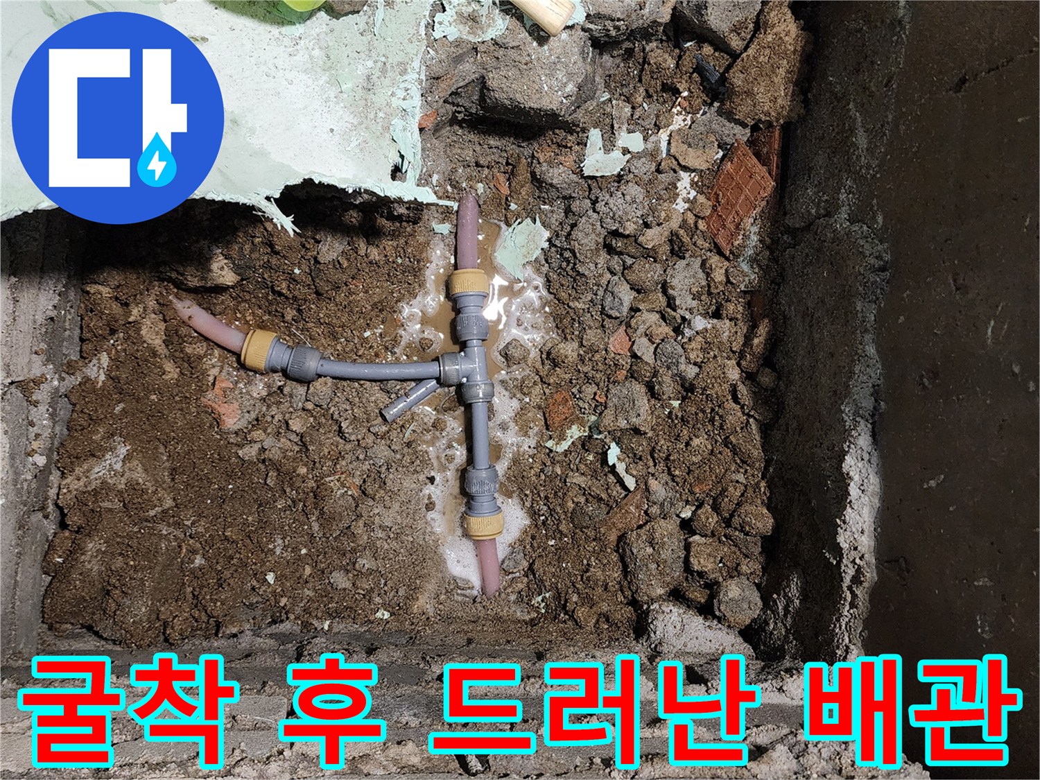 배관 분기점 주변의 젖은 흙과 노후된 수도 부속