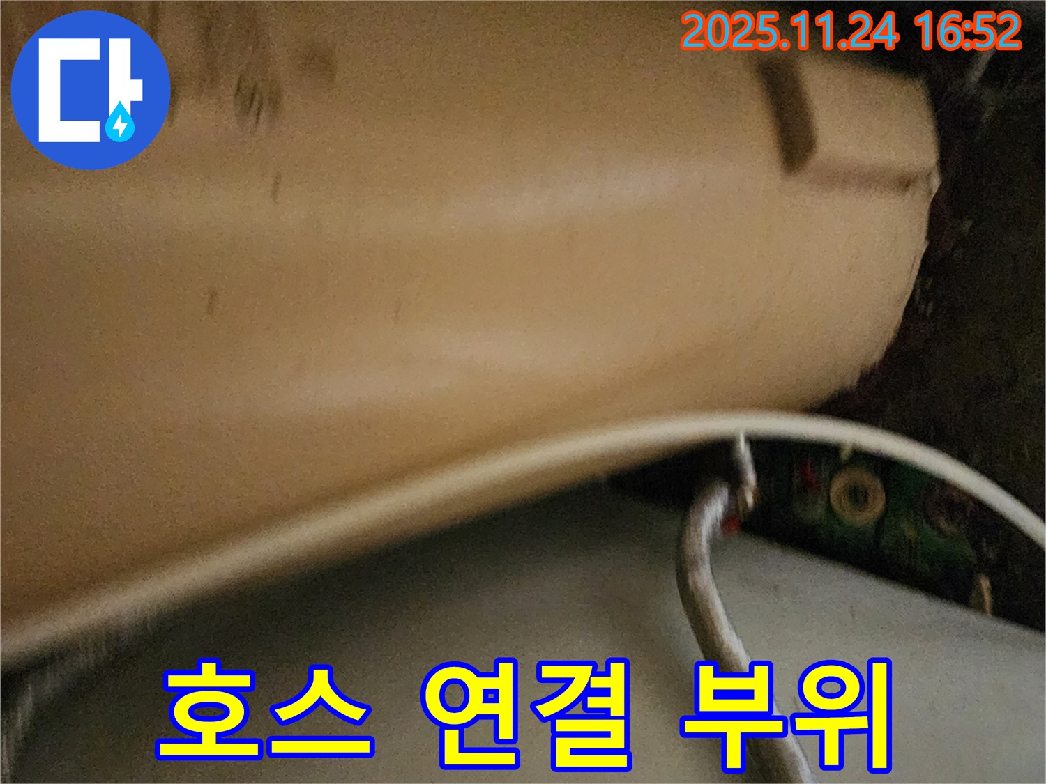 세탁기 배수 호스 연결 부위 - 헐거워진 호스 연결 부위에서 물이 새는 모습을 보여줍니다.