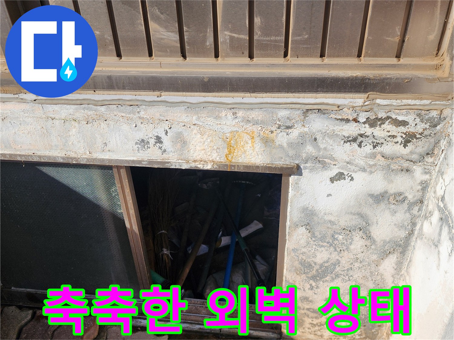습기가 침투하여 변색된 건물 외벽 하단부 모습