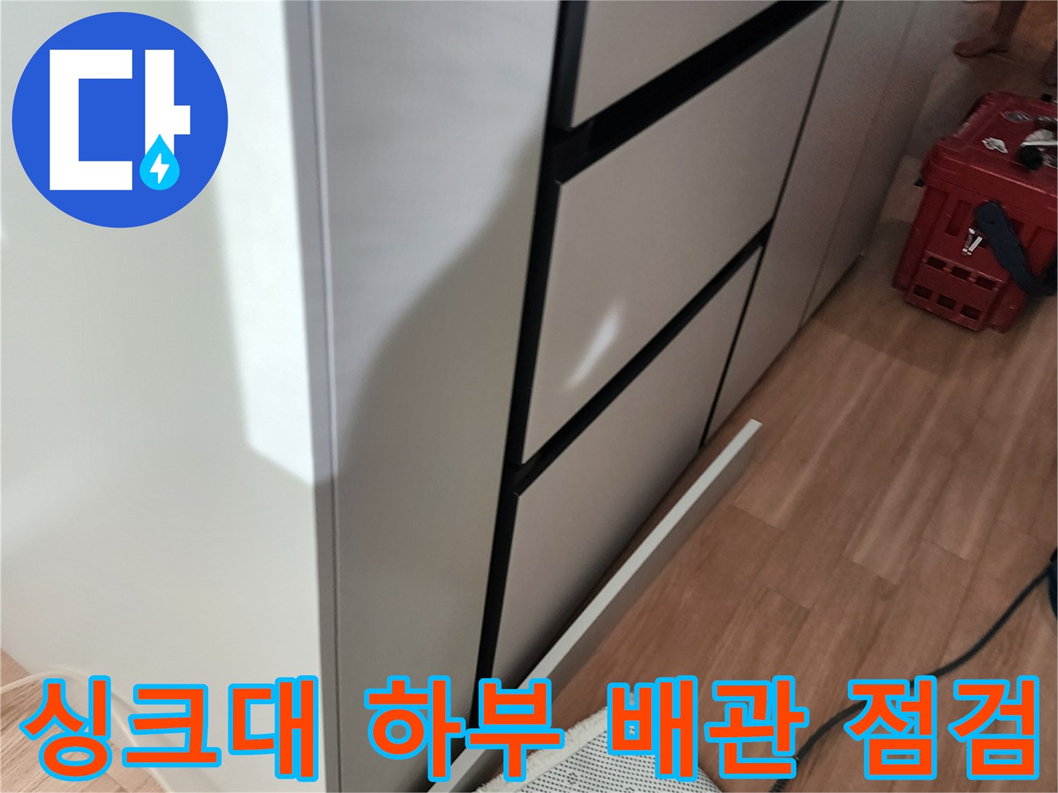 싱크대 밑 가구 아래쪽의 배관과 연결된 측정 장비 호스