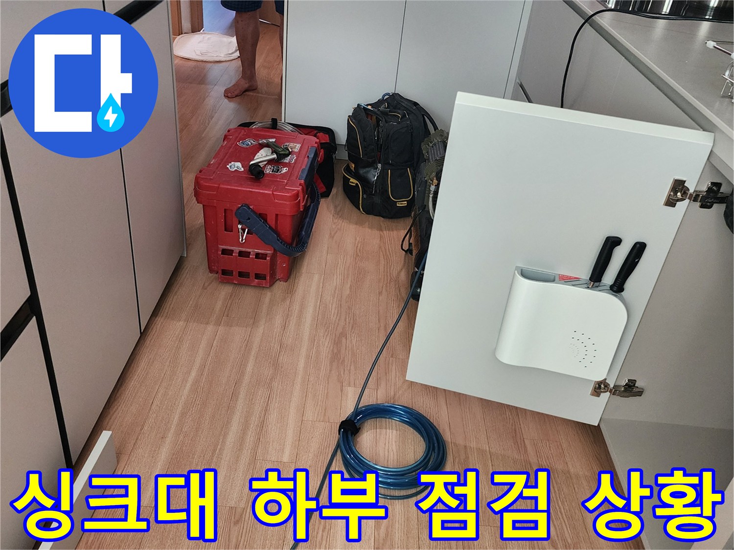 주방 싱크대 밑 배관 연결 부위를 확인하기 위해 장비를 배치한 작업 현장입니다.