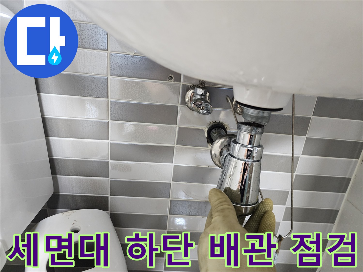 작업자가 세면대 아래쪽 연결 부위를 꼼꼼하게 확인하고 있습니다.