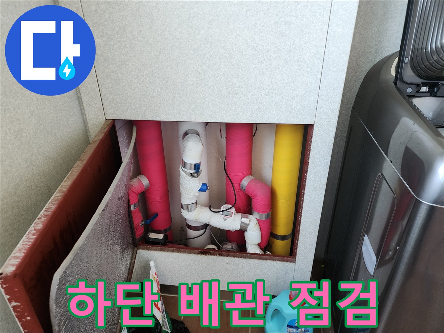 싱크대 하부의 분홍색 및 노란색 보온재 배관