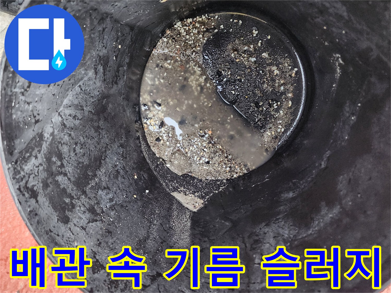 검은색 배수통 안에 가득 찬 기름 덩어리와 오물들