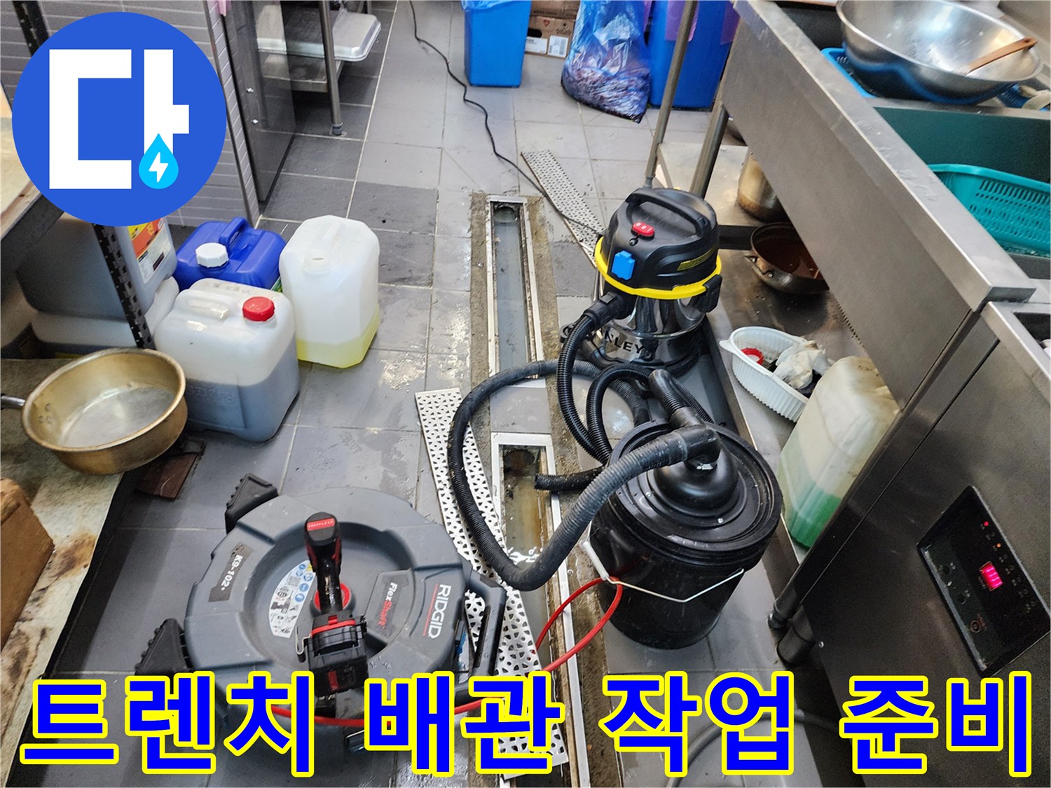 식당 트렌치 하단-배수 불량 해결을 위해 가동 중인 전동 장비와 흡입기