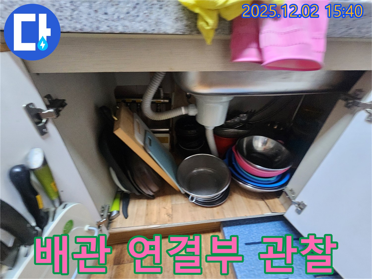 포천시 일동면 길명리에서 싱크대 하부 배관 연결부를 집중적으로 관찰하고 있습니다 - 연결 부위의 작은 틈새나 물방울을 찾아 누수 여부를 판단합니다.