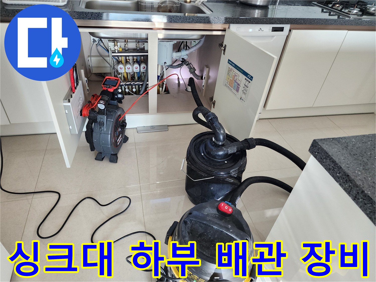 주방 싱크대 밑에서 작업 중인 석션기와 배관 탐지기