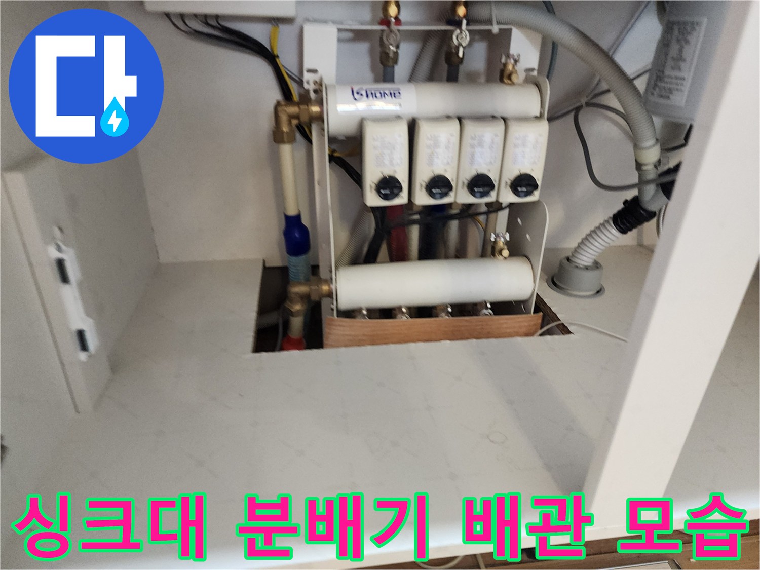 주방 싱크대 하부의 수도 분배기와 연결된 배관들의 상세 사진입니다.