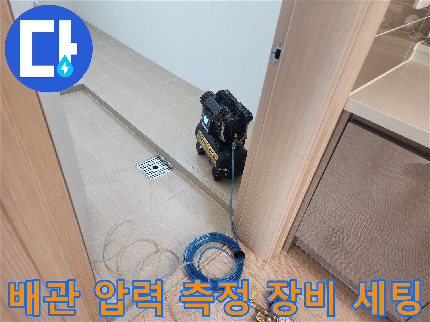검은색 공압 테스트기와 파란색 에어 호스가 연결된 모습