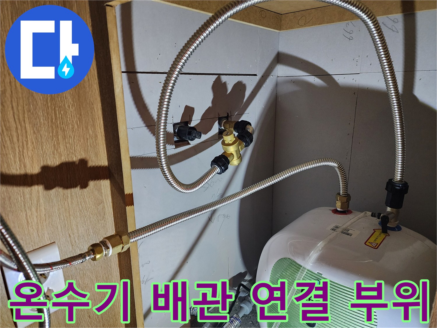 금속 호스와 황동 밸브가 연결된 전기 온수기 배관 구조