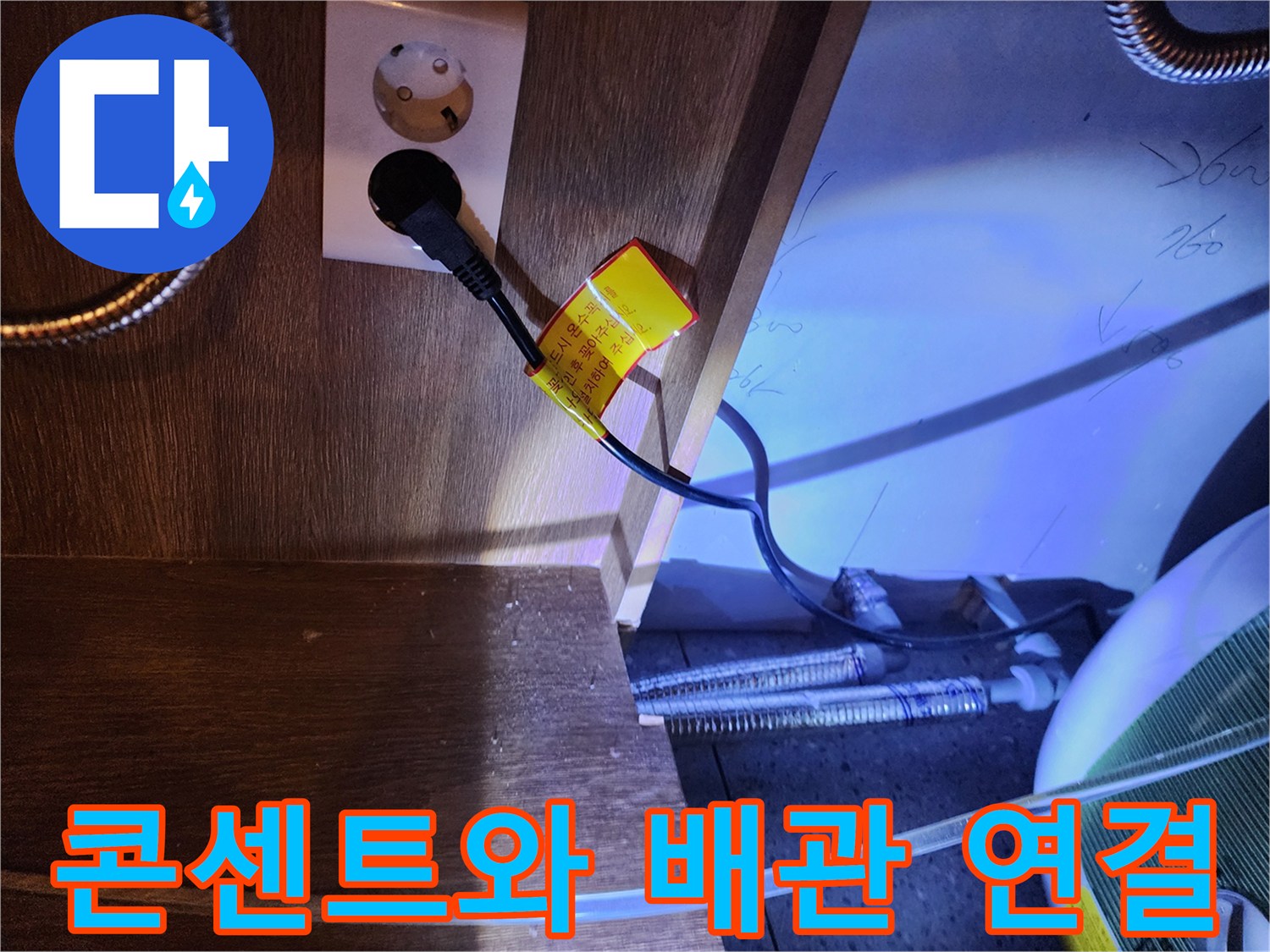 벽면 콘센트에 꽂힌 온수기 전원선과 금속 호스 부위