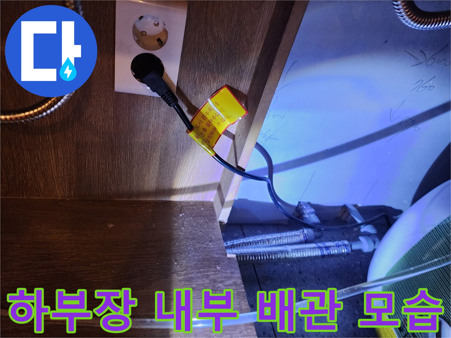 싱크대 하부 수납장 내부에 설치된 금속제 플렉시빌 호스와 콘센트