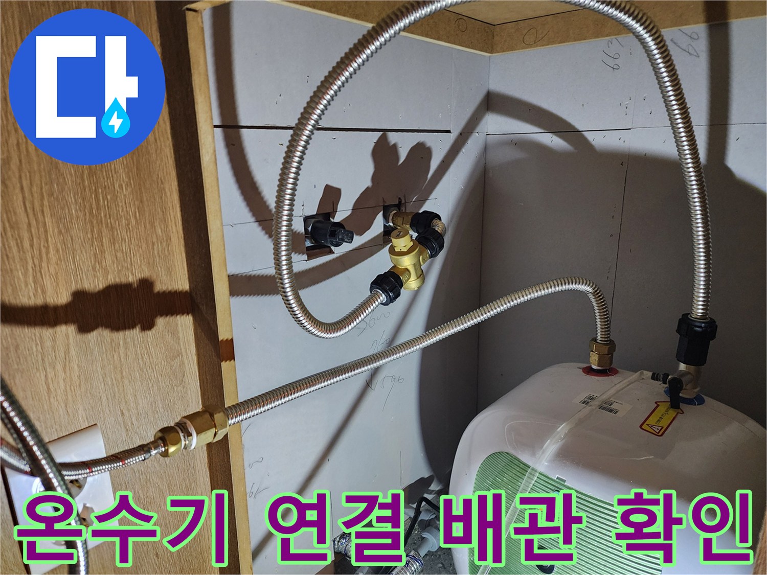 전기 온수기에 연결된 은색 금속 호스와 밸브의 상태 관찰
