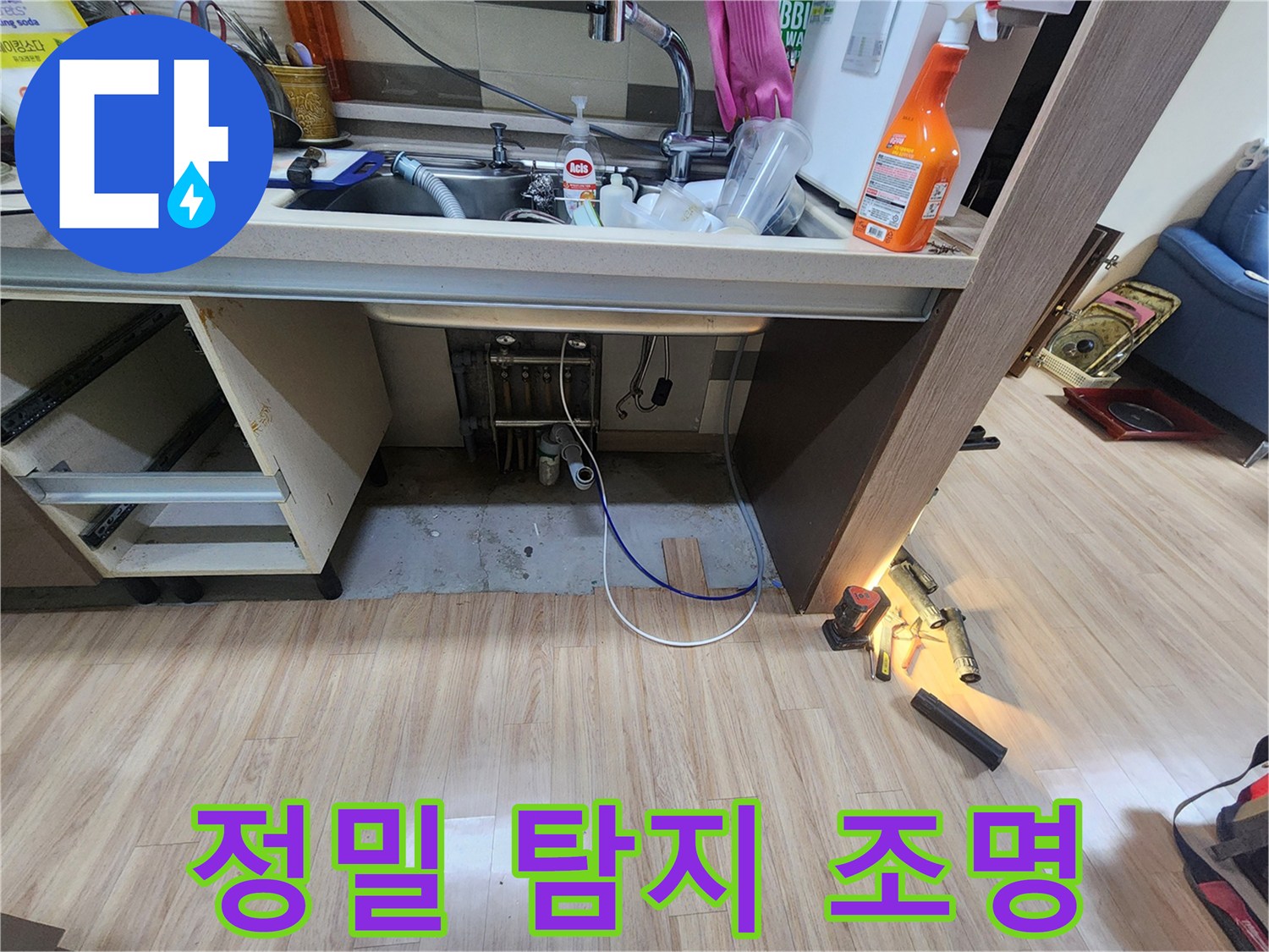 어두운-싱크대-하부-공간을-밝은-조명으로-비추며-누수-흔적을-찾아내는-전문가의-모습