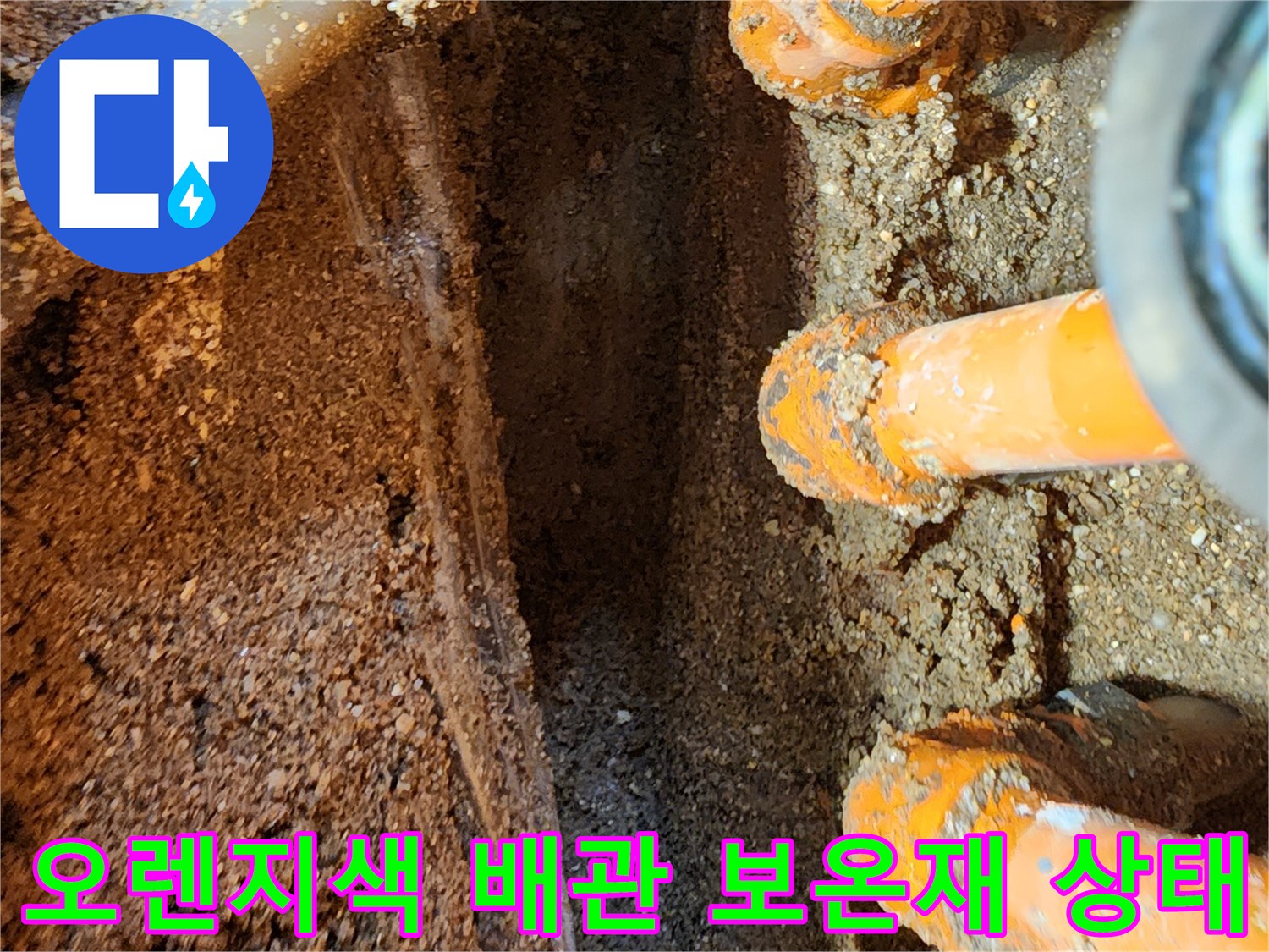 물기에 젖어 오염된 오렌지색 배관 보온재와 주변 토사