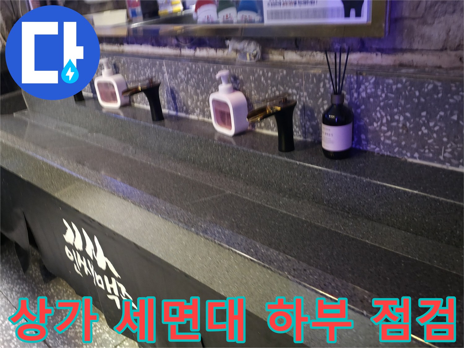 상가 건물 내 설치된 검은색 대리석 세면대와 수전 모습