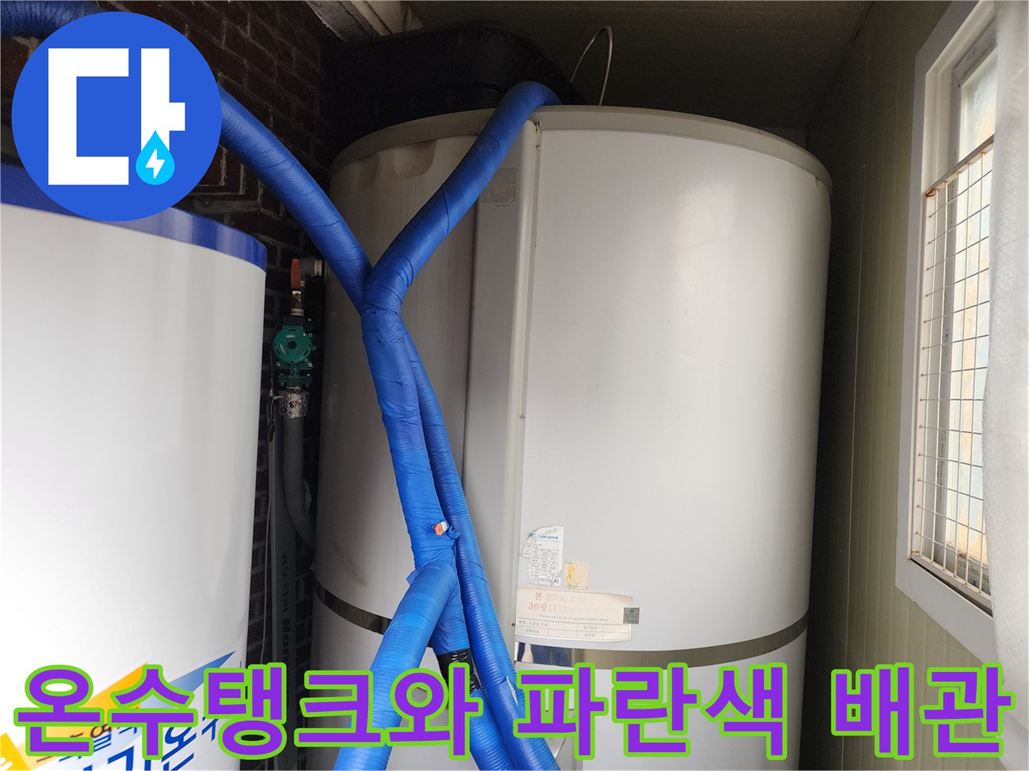 대형 온수 탱크와 파란색 보온재로 감싸진 배관의 모습입니다.