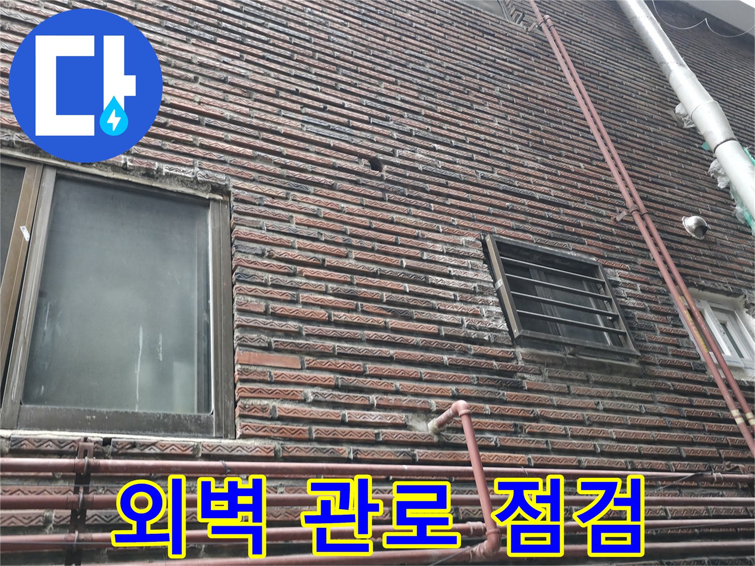 벽돌로 된 건물 외벽과 수직으로 설치된 배관들