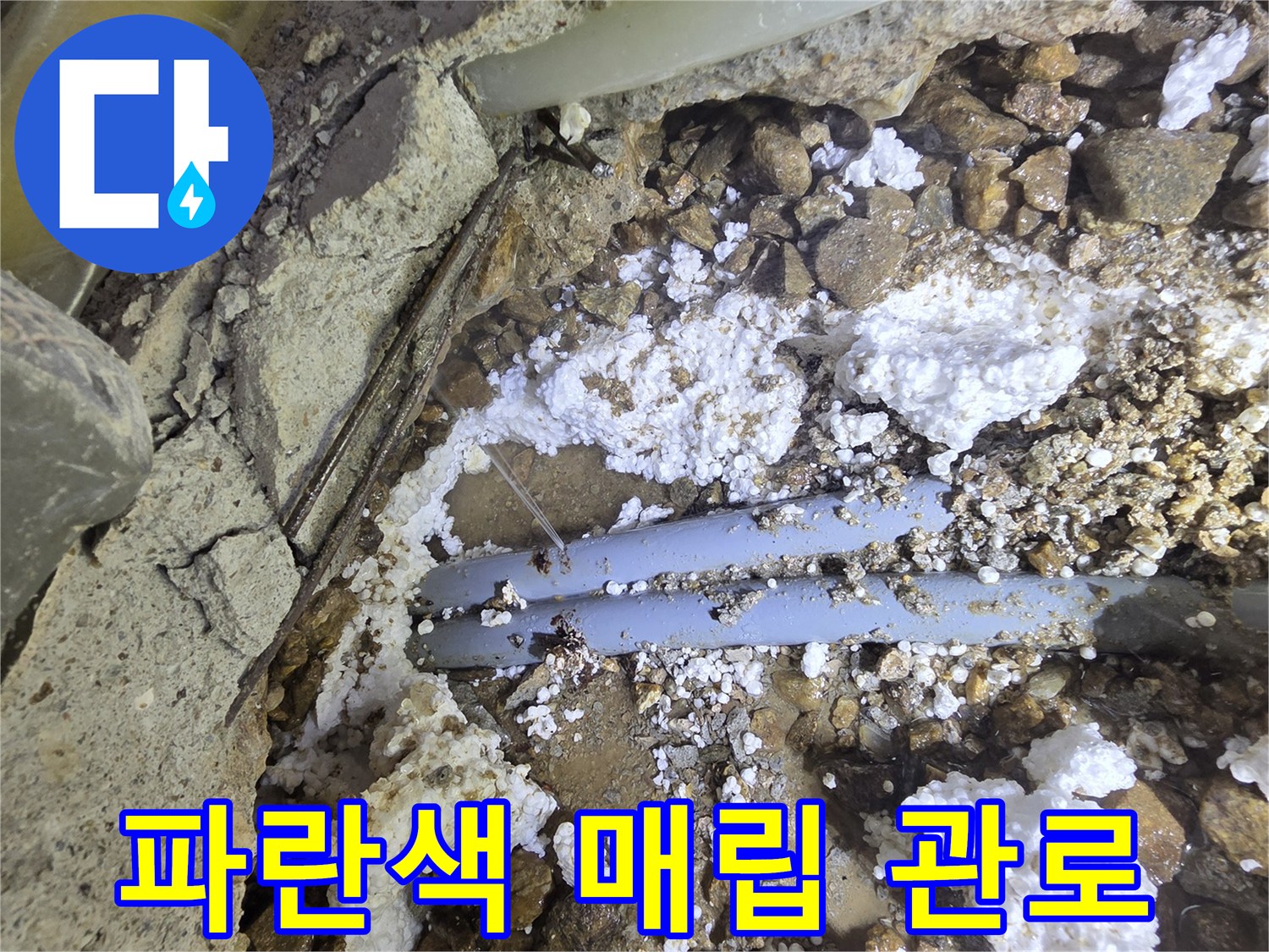 흙과 돌 사이 노출된 파란색 급수 배관
