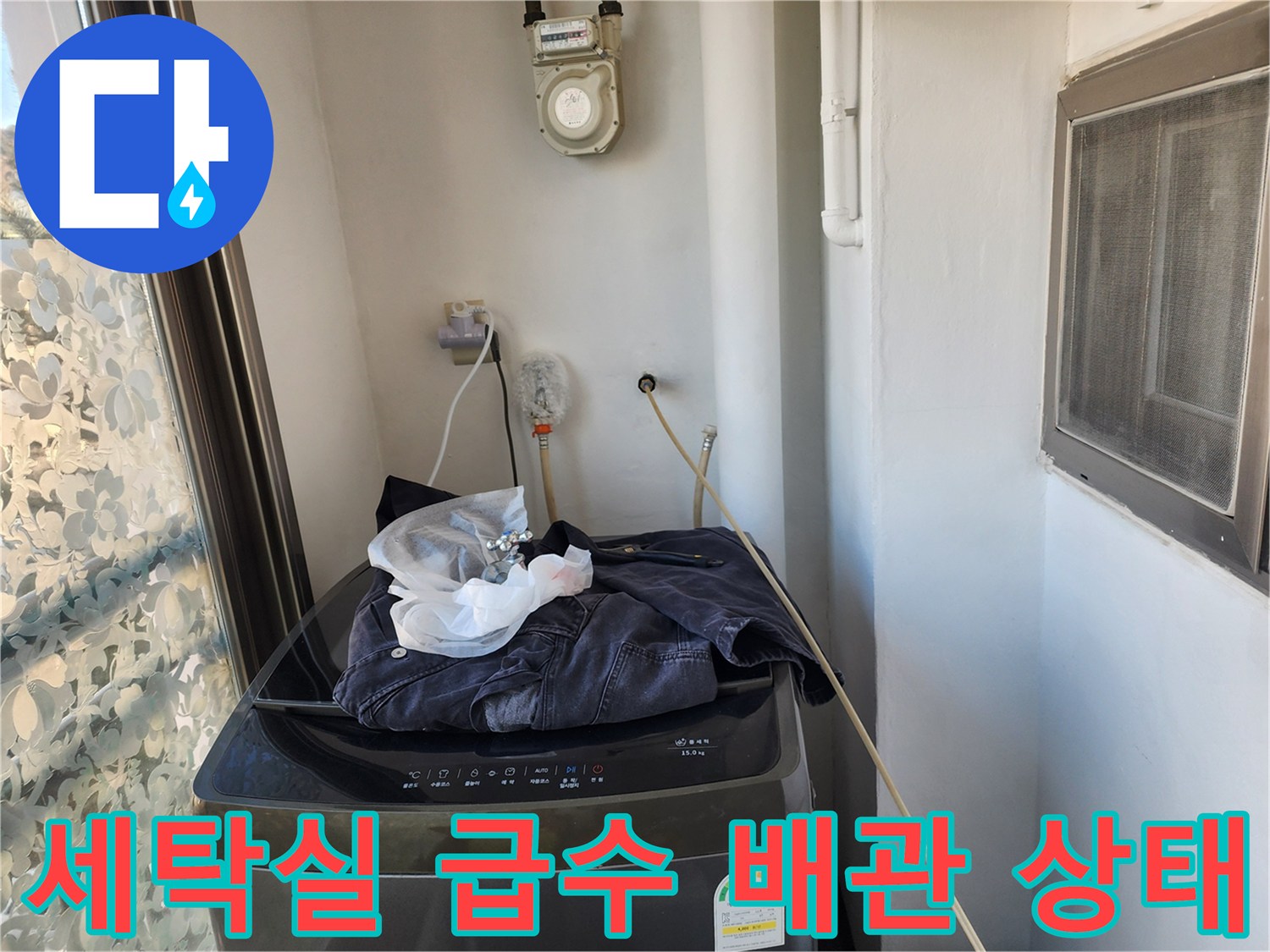 벽면에 고정된 수도 배관과 상단에 위치한 수도 계량기 모습입니다.