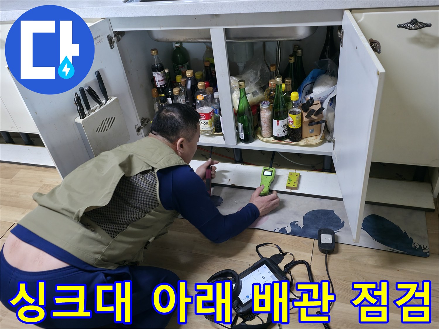 싱크대 하부 수납장 안쪽에서 가스식 탐지기로 배관 누수를 확인하고 있습니다.